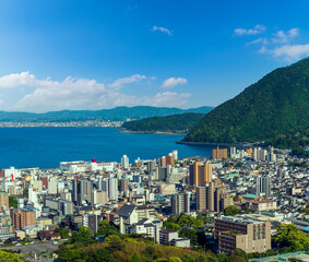 Fototapeta premium Cityscape view of Beppu city and Beppu bay with blue sky background, Oita, Kyushu, Japan
