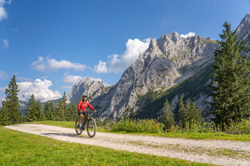 Fototapeta premium beautiful active senior woman with electric mountainbike in the spectacular Mountains of Raintal Valley, a side valley of Lechtal, Tyrol, Austria