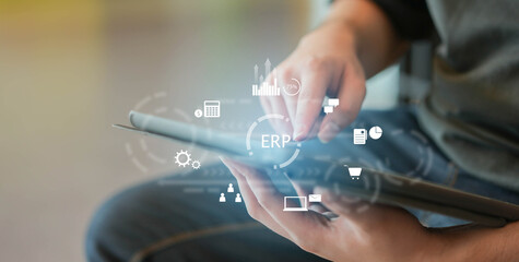 close up employee man hand hold digital let and using ERP program application to connect with team...