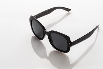 Sunglasses on a white reflective surface. Fashionable, stylish accessories.  Use it for a vacation...