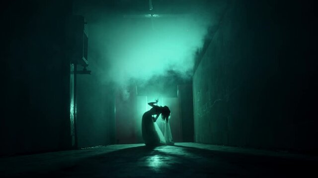 Dead zombie woman scaring in dark corridor. Creepy bride wearing wedding dress with veil. Deceased fiancee returned to life. Horrible klip for halloween, traditional usa holiday. Haunted house. 