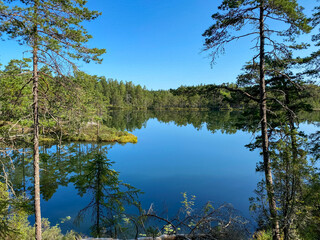 Beautiful Lake with reflections on the water in the Tiveden Nationalpark in Sweden at a sunny day with blue sky - Landscape Photography