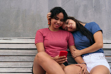 Young Lesbian Couple Enjoys Tender Moment While Spending Time On A Park Bench