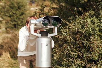 Man looks into a large telescope. Observation of nature through a telescope
