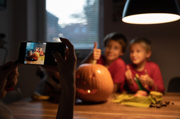 Taking photo of kids with Halloween pumpkin