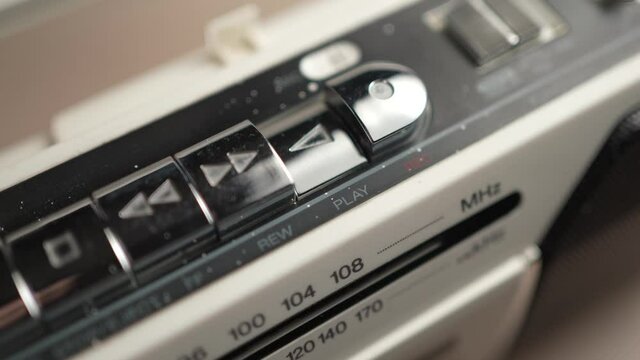 Finger Pressing The Play Button on a Radio Cassette Player Closeup