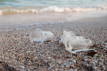 Fototapeta na wymiar Plastic and plastic bag, trash on the background of a sandy beach