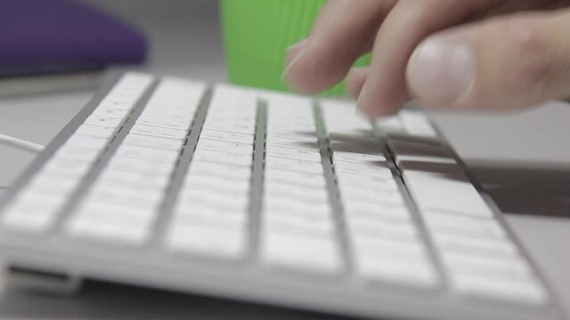 Computer work: Hands are typing on a macbook keyboard. Close-up