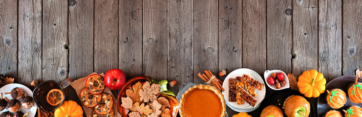Autumn desserts bottom border. Table scene with assorted sweet fall treats. Top view over a rustic...