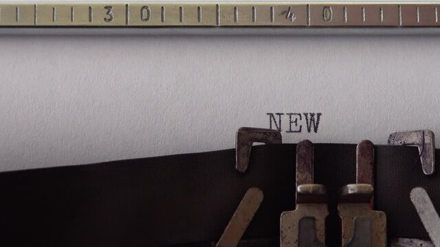 Typing phrase NEW CHAPTER on retro typewriter. Close up.
