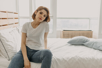 Cool looks of an Asian woman in a t-shirt and jeans relax in her apartment room.