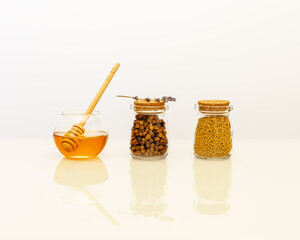 Bee products are an natural, folk medicine. Immune boosting food. Healthcare composition with perga, propolis and honey in glass jars and lavender flowers on a white background with copy space