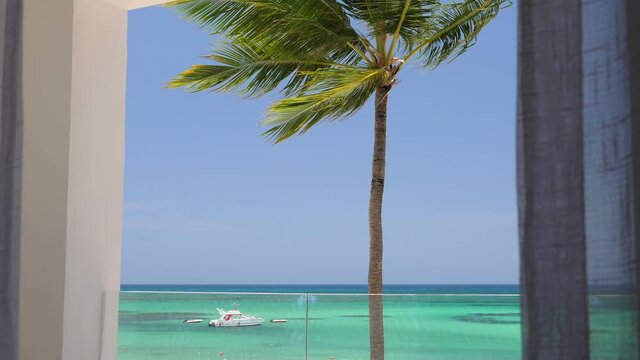 View from luxury balcony on caribbean shore with coconut palm tree and turquoise sea. Travel destinations. Dominican Republic