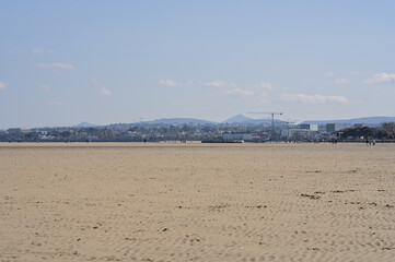 Beautiful bright view on South Dublin and the Mountains seen from Sandymount Beach, Dublin, Ireland during lowest tide. Walking people. Open spaces. High resolution