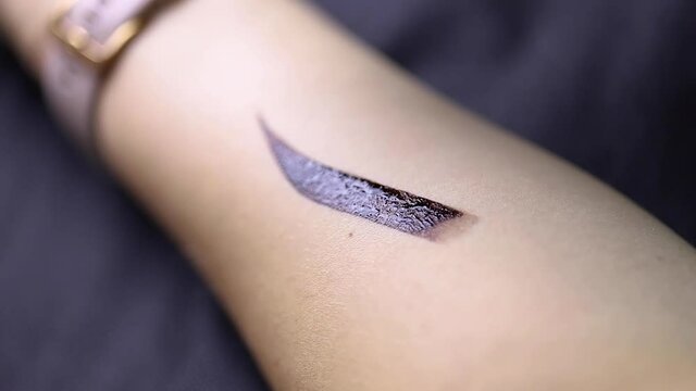 girl paints an eyebrow on her hand with henna for eyebrows.