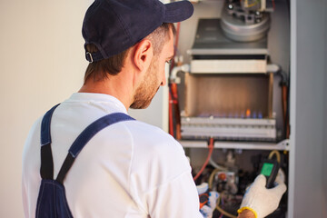 Customer service for the repair and adjustment of the gas boiler. The master checks the gas...