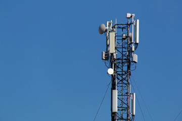 Mobile cell phone tower against the background of a blue sky and white cloud. Telecommunication TV...