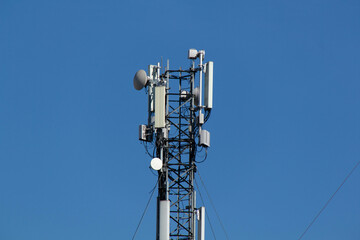 Mobile cell phone tower against the background of a blue sky and white cloud. Telecommunication TV...