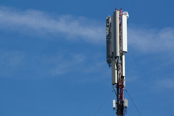 Mobile cell phone tower against the background of a blue sky and white cloud. Telecommunication TV...