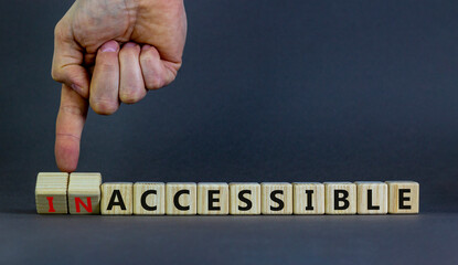 Accessible or inaccessible symbol. Businessman turns wooden cubes, changes the word Inaccessible to Accessible. Beautiful grey background, copy space. Business, accessible or inaccessible concept.