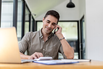 Man talking on the phone in the office, He is a businessman executive of a startup company founded with partners, He is a young and energetic executive and the company's earnings continue to grow.