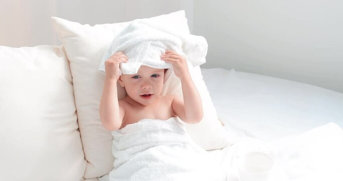 little girl 2 years old lying on a white bed. in slow motion