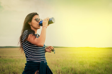 woman in the field drinking water, concept of woman in the field drinking water