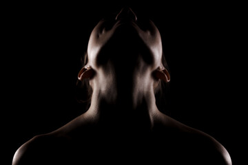 side lit silhouette portrait of a beautiful young woman against dark backgroung