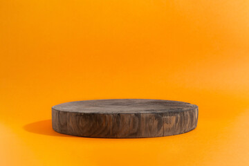 Empty showcase of wooden circle podium on orange background. Showcase display