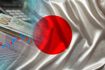 Japan national flag on satin, dollar bills, computer, concept of global trading on the stock exchange, falling and rising prices for world currency
