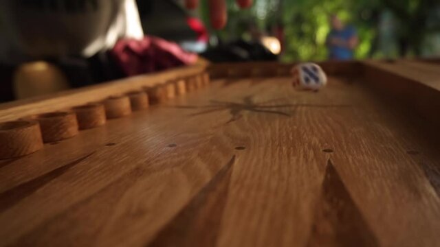 dice for playing backgammon fall on a wooden board, hit the boards and bounce