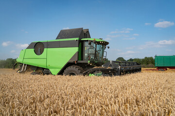 Fototapeta na wymiar Getreideernte - Moderner Mähdrescher bei trockenem Erntewetter auf dem Feld im Einsatz.