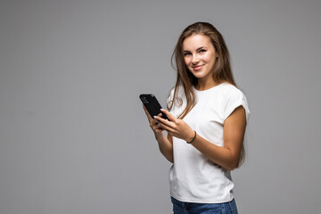 Naklejka premium Happy woman using smartphone over gray background
