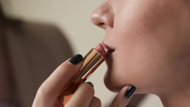 Woman makeup artist applying lip gloss on lips makeup model with cosmetics brush
