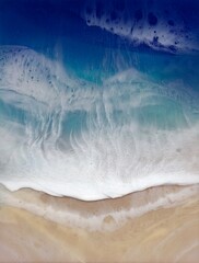 Aerial view on sea wave with white foam and light beige sand. 