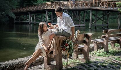 Obraz na płótnie Canvas Young married couple in a park near the river, on a date in nature.