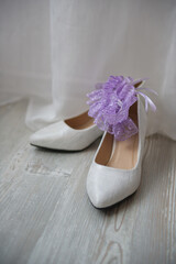 White shoes and a bride's garter. Wedding dressing in detail.