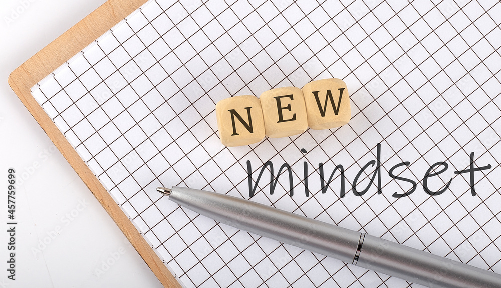 Poster new mindset text concept written on wooden cubes blocks and notebook