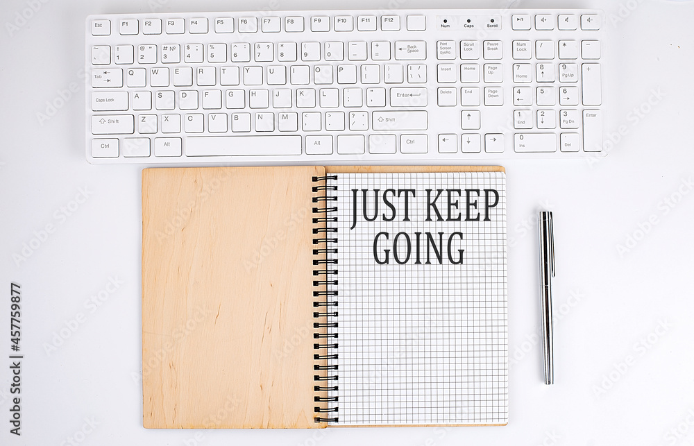Poster just keep going text on the notebook with keyboard on white background