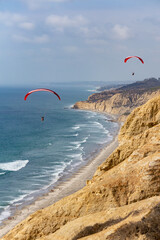 Two Paragliders Over Cliffs and Ocean