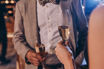Close-up of well dressed couple holding champagne flutes
