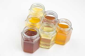 Hexagonal jars with different types and colors of fresh flower honey. vitamin food for health and life