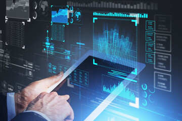 Businessman wearing formal suit is holding tablet in his hands