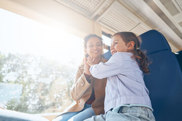 Happy mother with little daughter having fun while traveling by train together