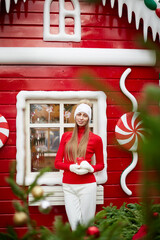 The girl stands near the candy house at the Christmas market