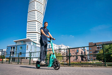 Young man riding an electric scooter down the streets in Malmo. Ecological transportation concept.  © Aerial Film Studio