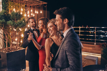 Beautiful young people dancing and smiling while spending time on luxury party