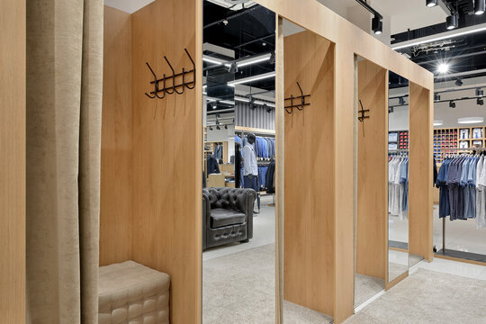 Row of empty fitting rooms with fabric curtains in a men's clothing store
