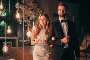 Fototapeta premium Beautiful young couple in formalwear spending time on night party