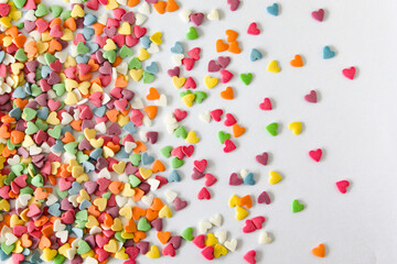 Fototapeta na wymiar Colorful heart confetti scattered elegantly across a bright canvas, creating a playful and whimsical atmosphere with room for text.